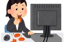 デスクでお菓子を食べるOL