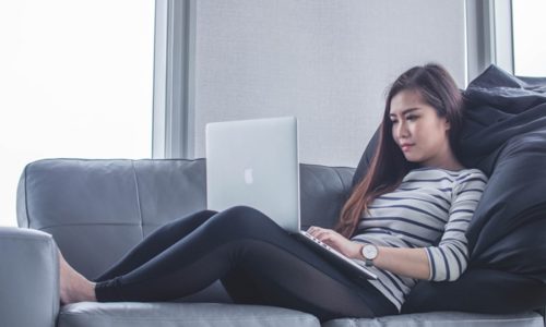 ソファでノートパソコンをする女性