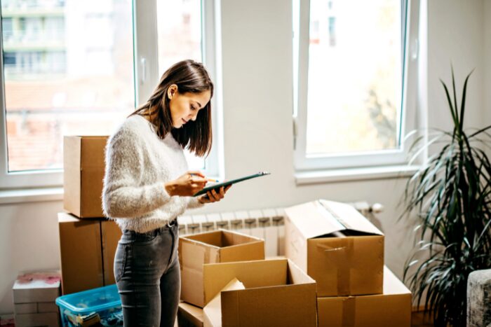 引っ越しの荷造りをしている女性