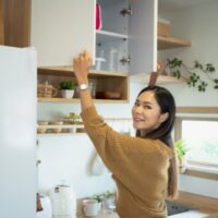 キッチンの棚を片付けている女性