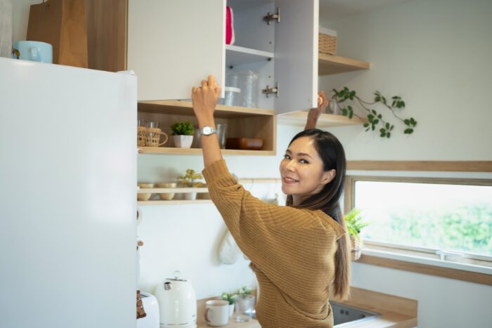 キッチンの棚を片付けている女性