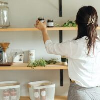 オープンシェルフの整理をしている女性