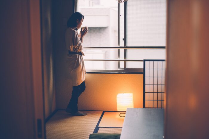 アパートでたたずむ女性