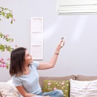 エアコンをつける女性
