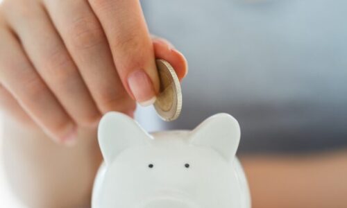 貯金箱にコインを入れる手
