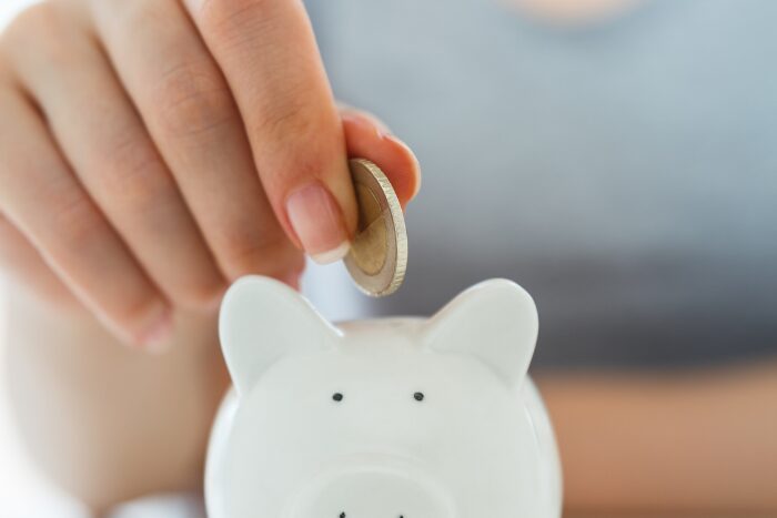 貯金箱にコインを入れる手