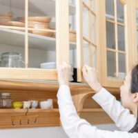 食器棚を開けている女性