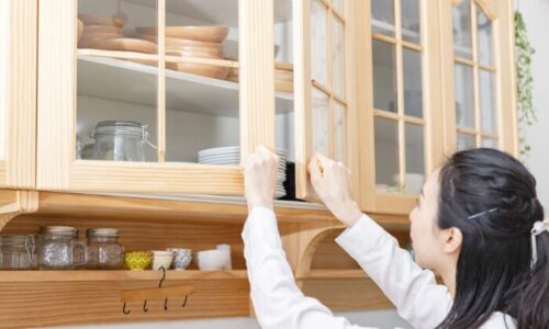 食器棚を開けている女性