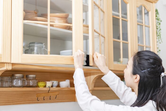食器棚を開けている女性