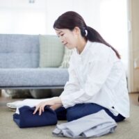 服を畳んでいる女性