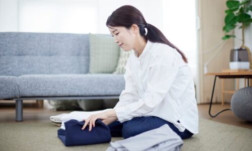 服を畳んでいる女性