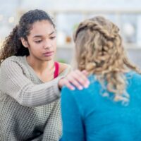 友人をなぐさめている女性