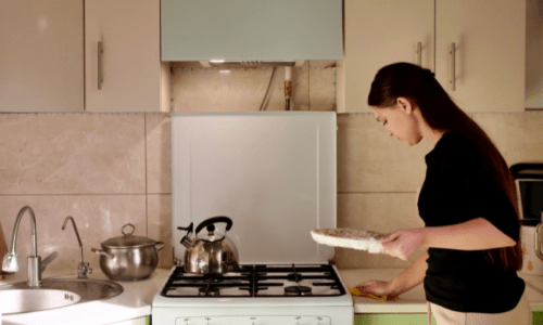 キッチンのカウンターを拭いている女性