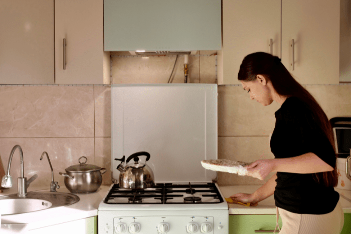 キッチンのカウンターを拭いている女性