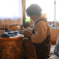 こたつで編み物をしている女性