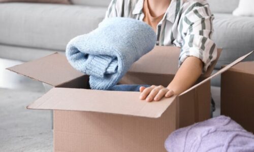 ダンボールにセーターを入れている女性
