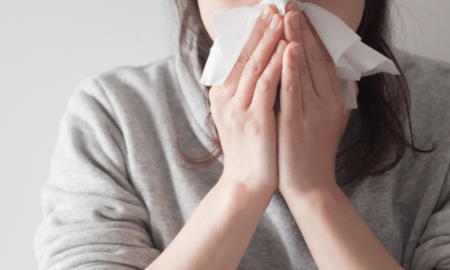 花粉症で鼻をかむ女性