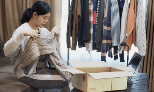 捨てる服をチェックしている女性