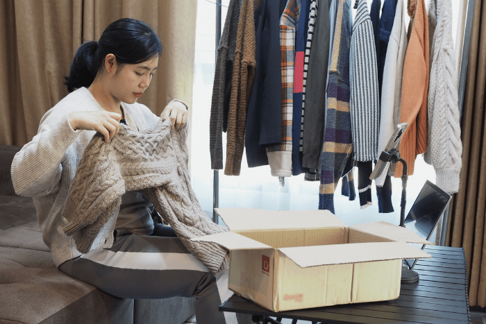 捨てる服をチェックしている女性