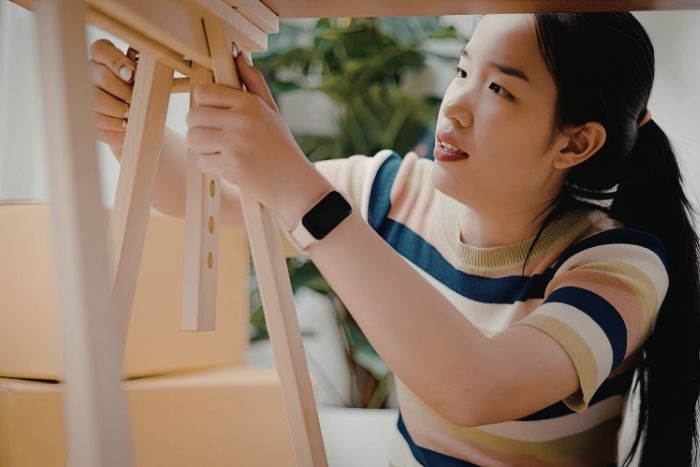 家具を組み立てる若い女性