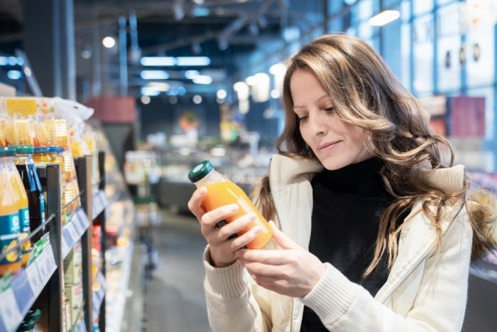 スーパーで食品を選んでいる女性