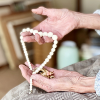 アクセサリーを持つおばあさんの手