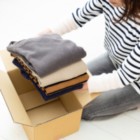 箱に衣類を入れている人