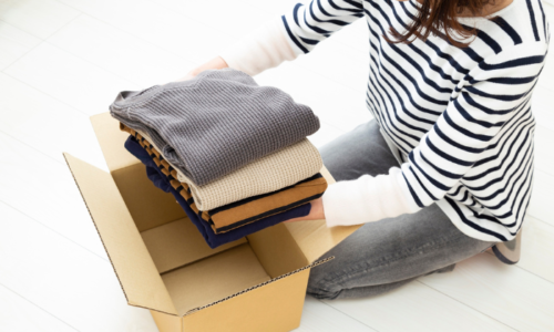箱に衣類を入れている人