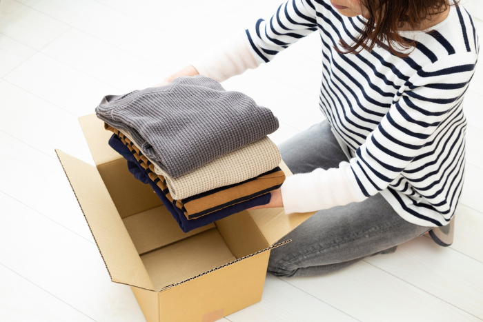 箱に衣類を入れている人