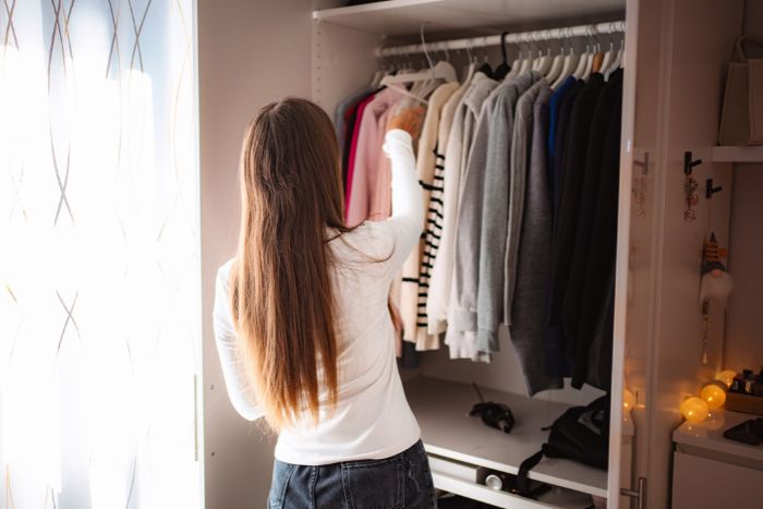 クローゼットの中の服を見直している人
