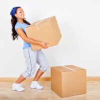 ダンボールを運んでいる女性