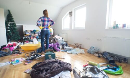 散らかった部屋に立つ女性