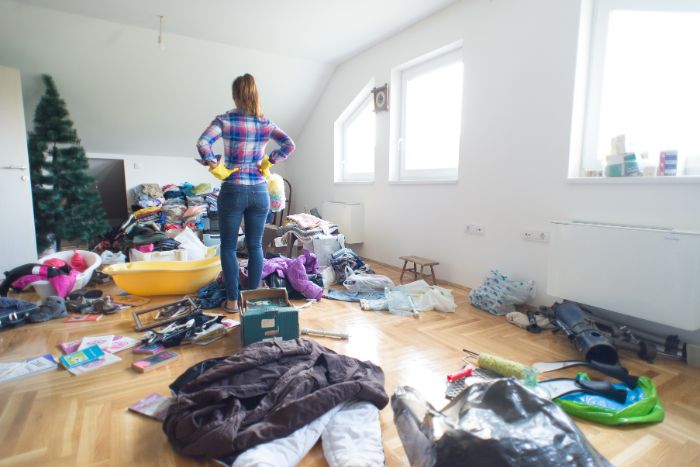散らかった部屋に立つ女性