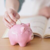 豚の貯金箱にお金を入れる