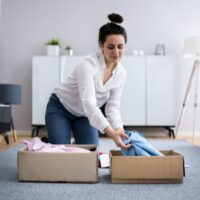 服を箱にしまっている女性
